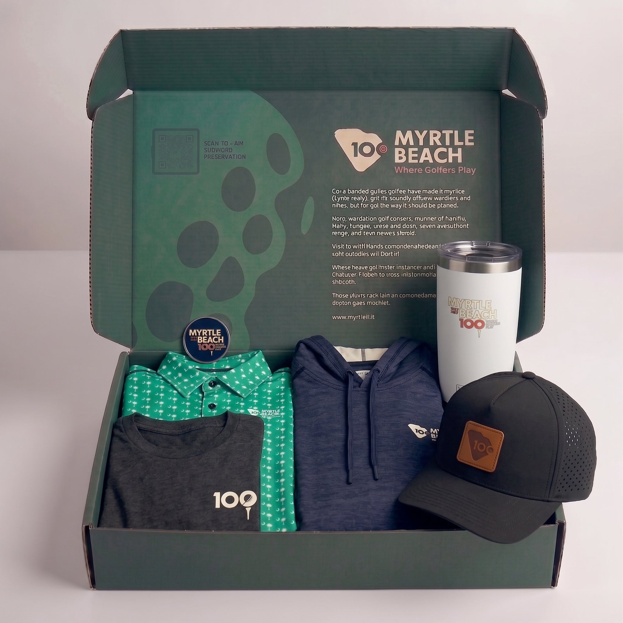 An open branded box containing a green patterned shirt, a navy hoodie, a black graphic T-shirt, a white insulated tumbler, and a black baseball cap with a brown patch, all arranged on a light gray background.