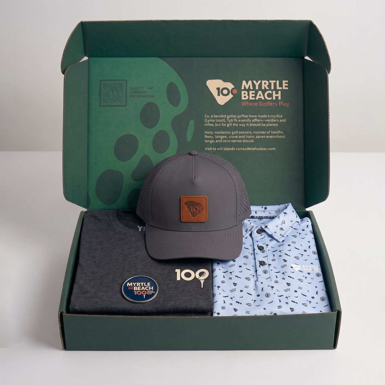 A green branded box opened with a grey graphic t-shirt, a grey cap and a blue printed polo shirt.