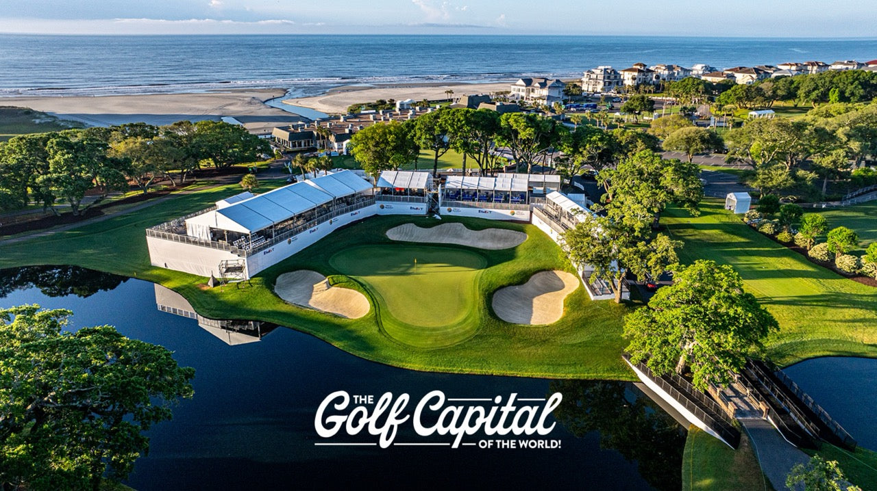 Aerial view of a golf course with a green putting green, sand bunkers, water features, trees, beach, and ocean in the background. Large text at the bottom reads 'The Golf Capital of the World!'.
