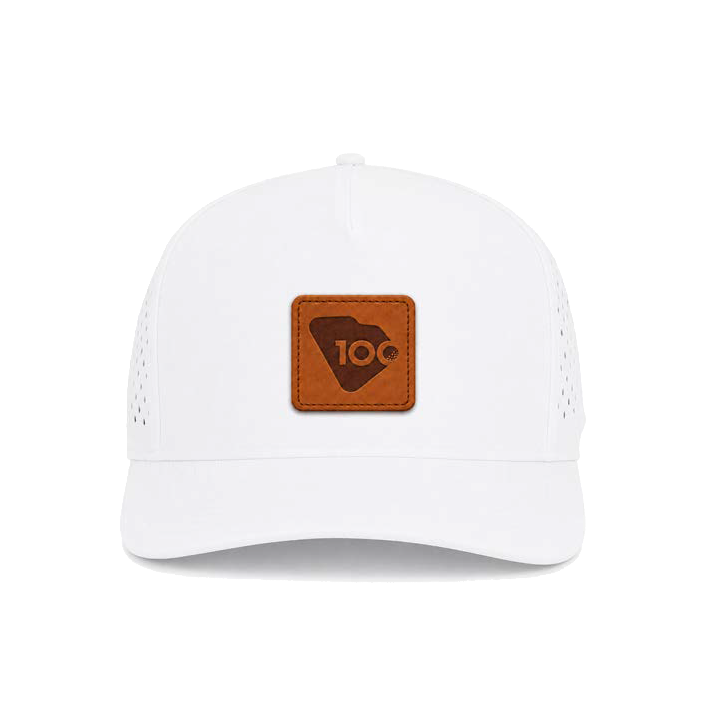 A white structured trucker-style cap with perforated side and back panels and a brown rectangular leather patch on the front.